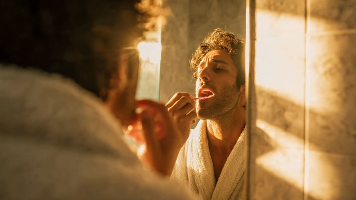 Morning Routine: Ayurveda ke 5 Powerful Tips an indian person doing tongue cleaning in bathroom