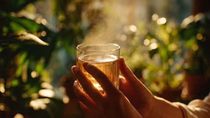 Morning Routine: Ayurveda ke 5 Powerful Tips close up of hands holding a glass of warm water wi